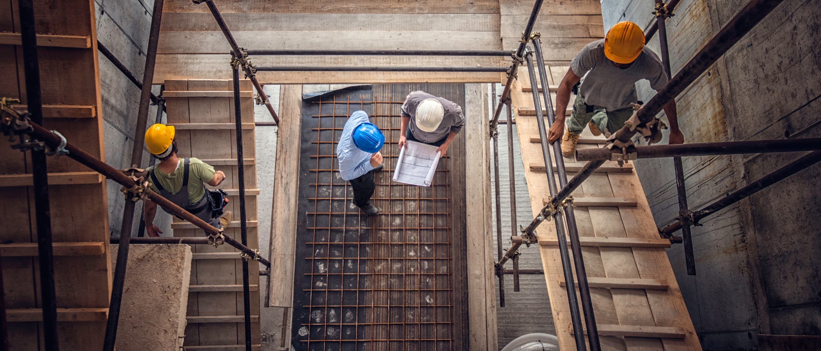 Construction workers reviewing blueprints on site